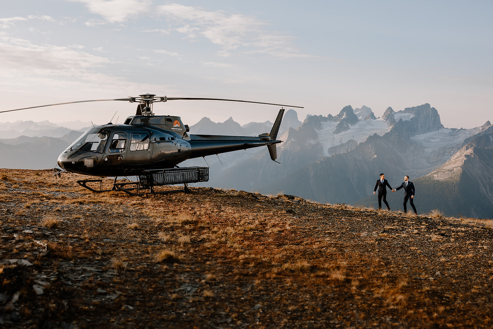 how to plan a Banff helicopter wedding/elopement - groom and groom walking towards the helicopter