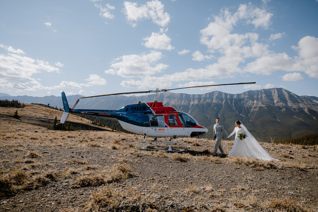 Couples walking toward the helicopter on their wedding day in Banff