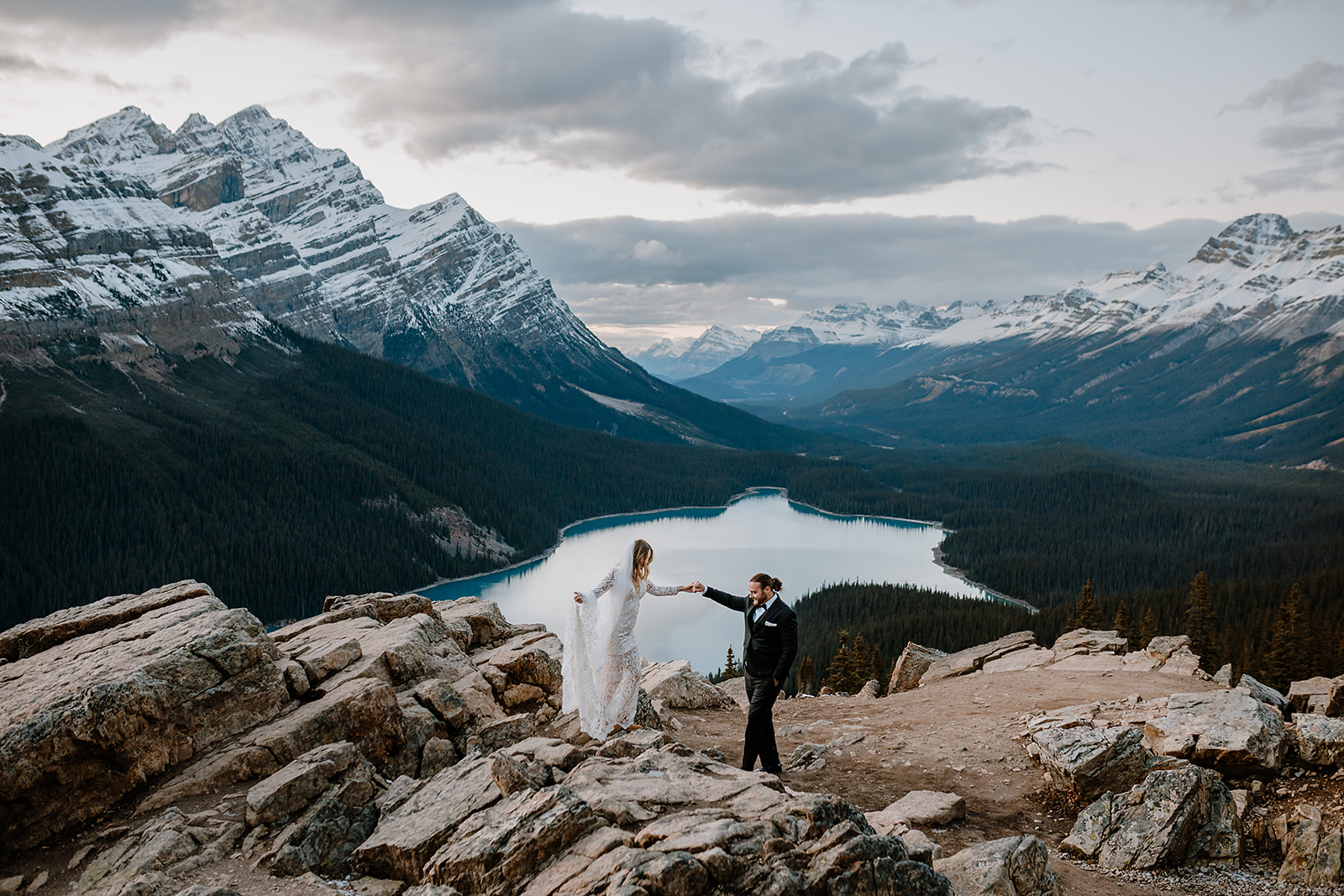 Bride and groom exploring Peyto Lake, a turquoise lake in Banff on their elopement day 