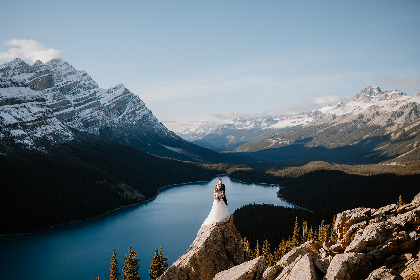 a couple stands on top of a rock during a Bow Lake Wedding