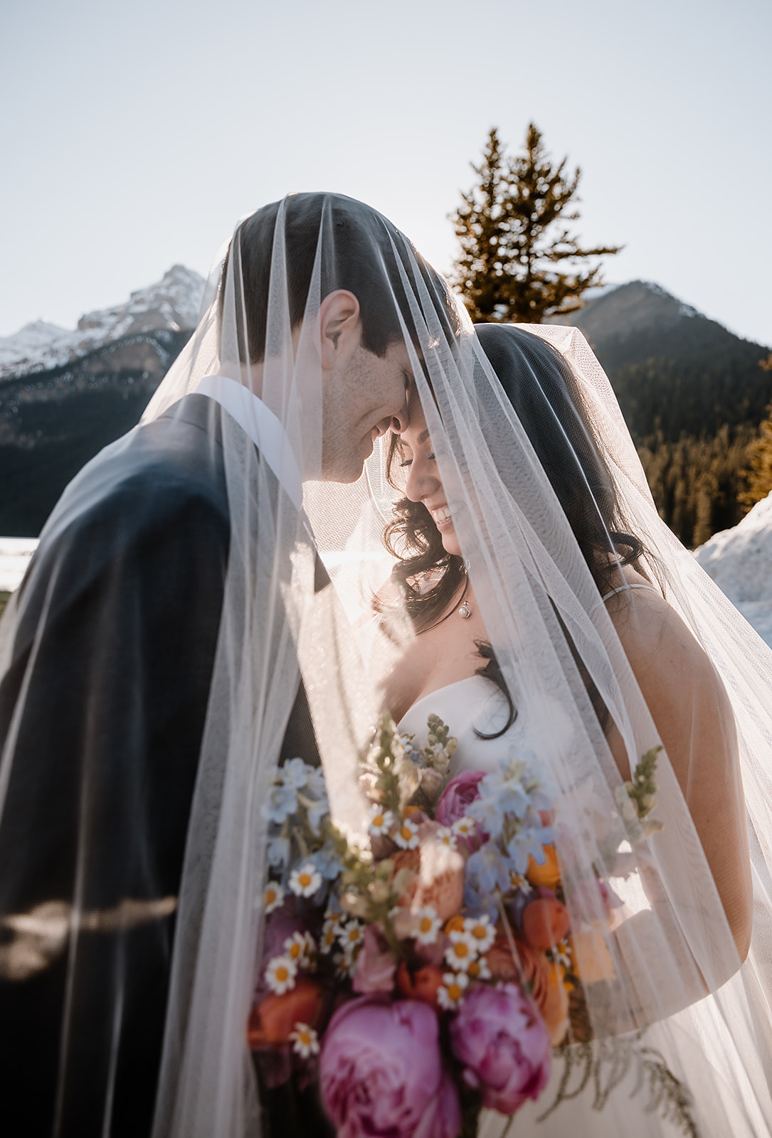 get-married-in-Banff a bride and groom under the veil while they get married in Banff