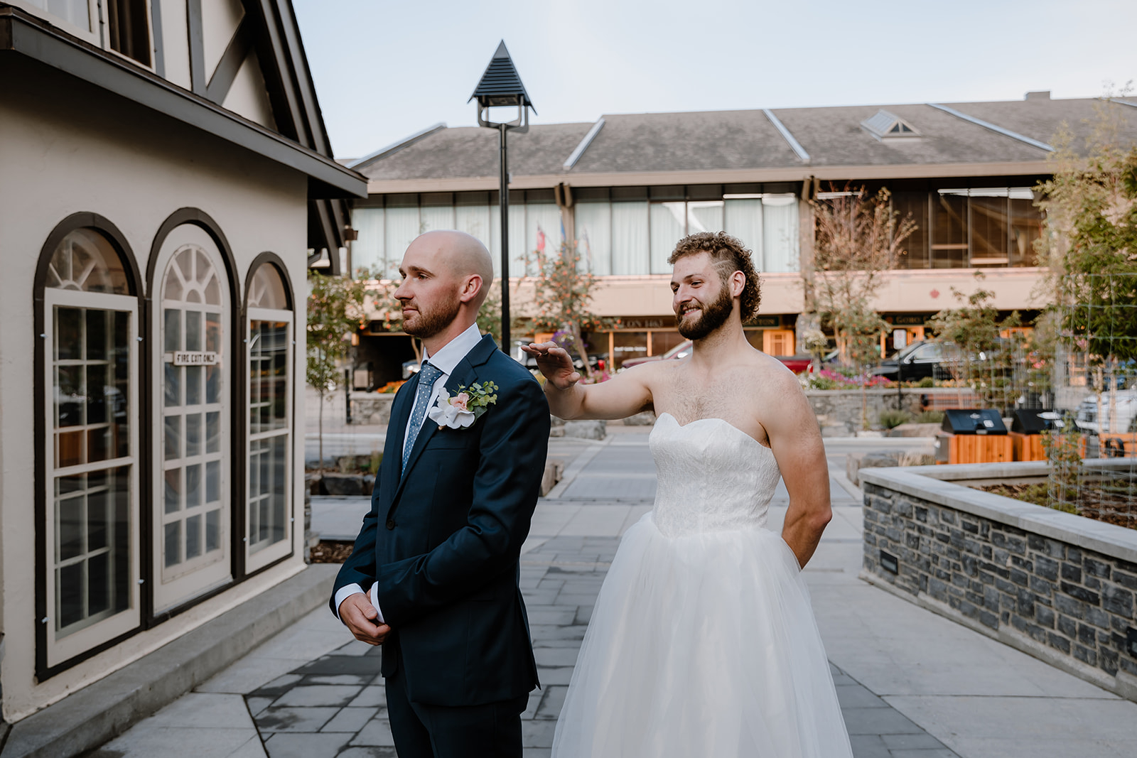 lake-Minnewanka-wedding A playful first look moment as a groomโs friend surprises him in a wedding dress for laughs at a Lake Minnewanka Wedding